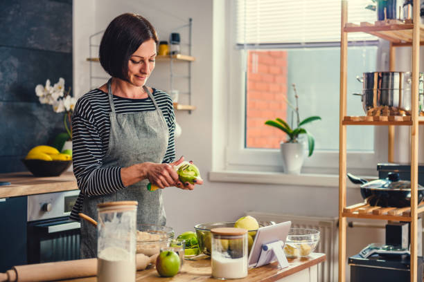 istock Woman peeling apples in the kitchen 1004463714