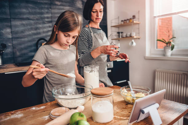 istock Mother and daughter making dough for apple pie 1004464272