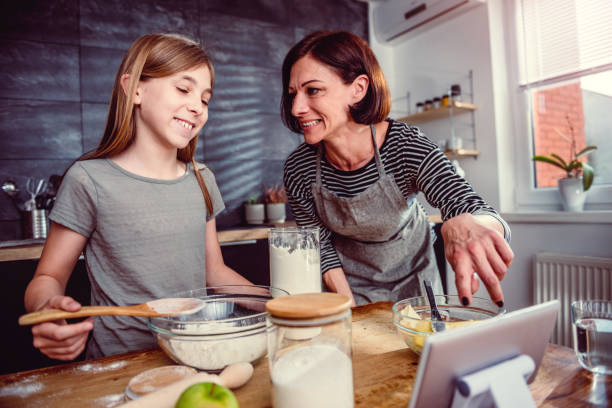 istock Mother and daughter making dough for apple pie 1004464464