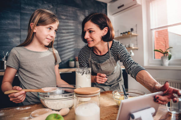 istock Mother and daughter making dough for apple pie 1004469320