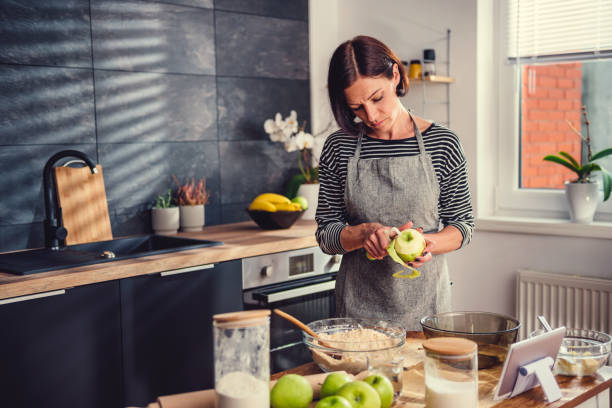 istock Woman peeling apples in the kitchen 1004469414