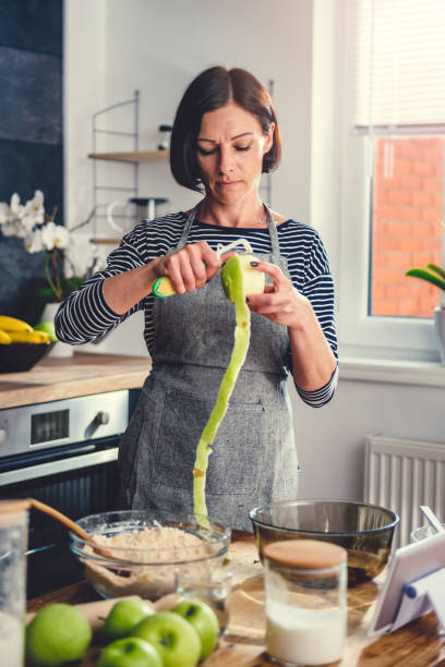 istock Woman peeling apples in the kitchen 1004470426