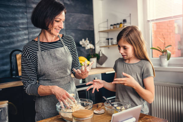 istock Mother and daughter making dough for apple pie 1004476132