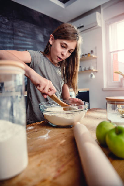 istock Girl mixing flour and sugar into bowl 1004480424