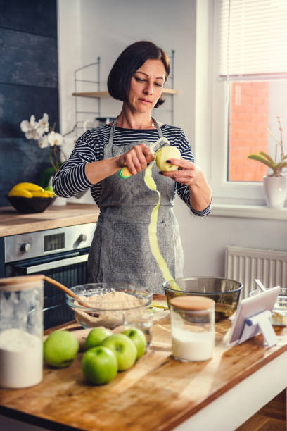 Woman peeling apples in the kitchen