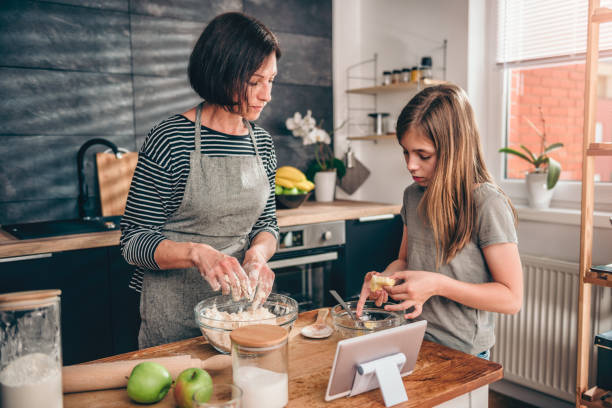 istock Mother and daughter making dough for apple pie 1004484964