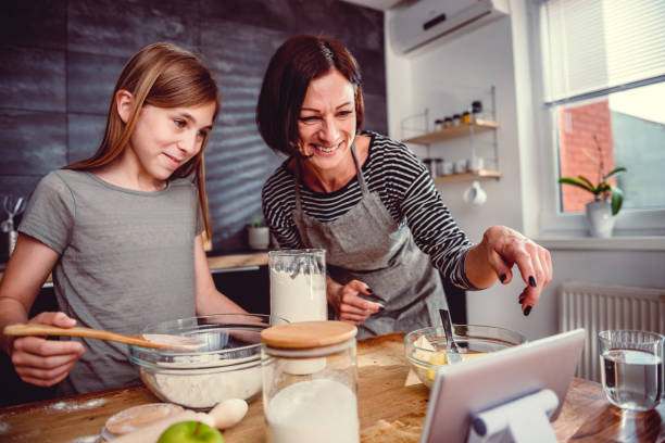 istock Mother and daughter making dough for apple pie 1004485158