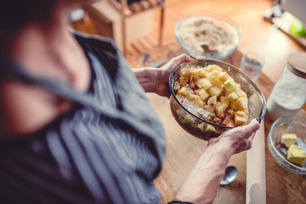istock Woman making apple pie on wooden table 1004486752