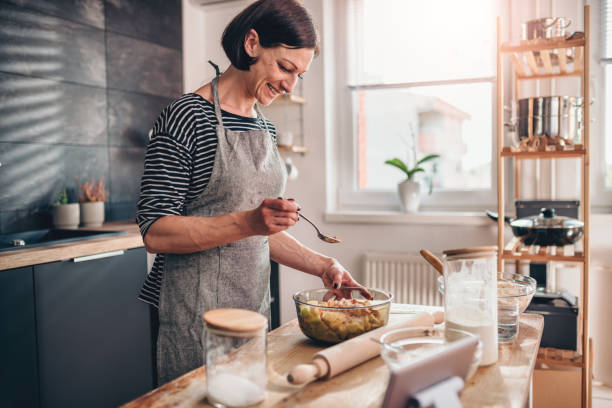 женщина делает яблочный пирог на деревянном столе - cooking thanksgiving women baking стоковые фото и изображения