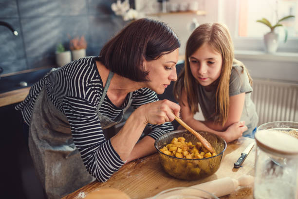 istock Mother and daughter tasting apple pie filling 1004490232