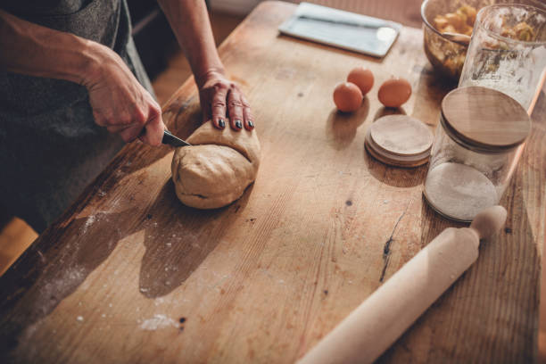 istock Woman cutting dough on the wooden table 1004491100