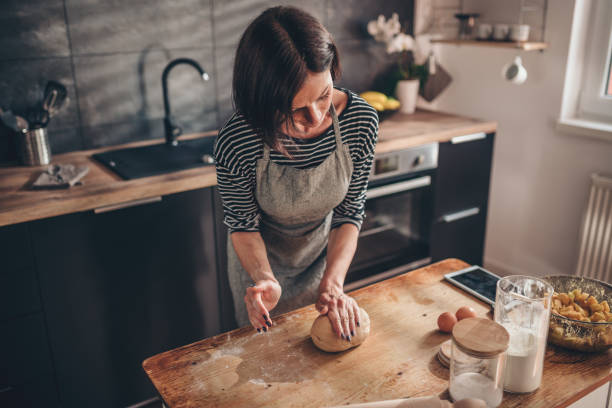 istock Woman kneading dough on the wooden table 1004493824