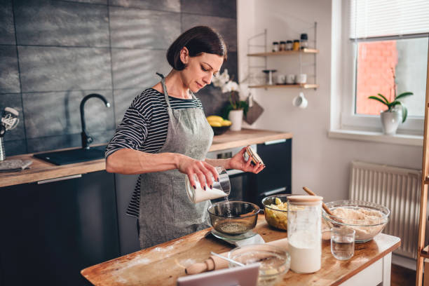 женщина измерения сахара на кухне масштаба - cooking thanksgiving women baking стоковые фото и изображения