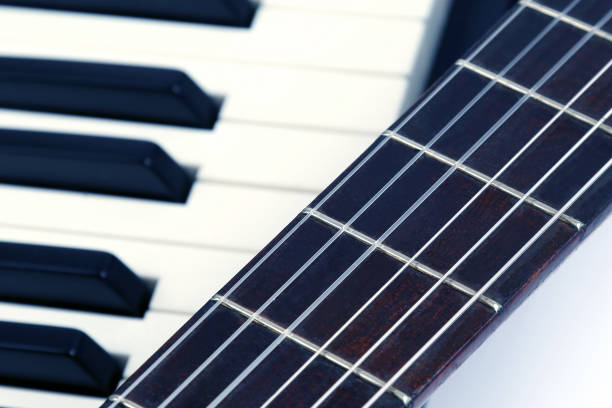 istock piano keys and classical guitar close up on white background 1004494960