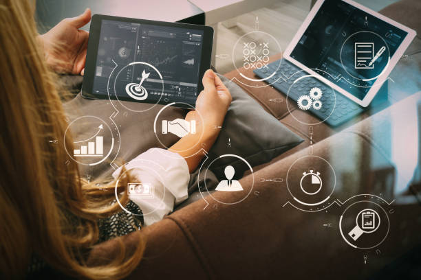 istock brunette woman using digital talet and laptop computer on sofa in living room 1004513792