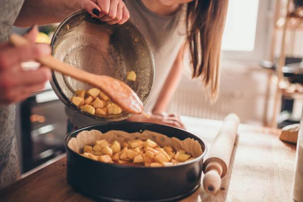 istock Woman pouring apple filling into baking pan 1004518564