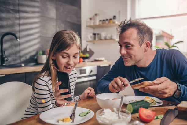 istock Daughter showing text message on smart phone to a father 1004528982