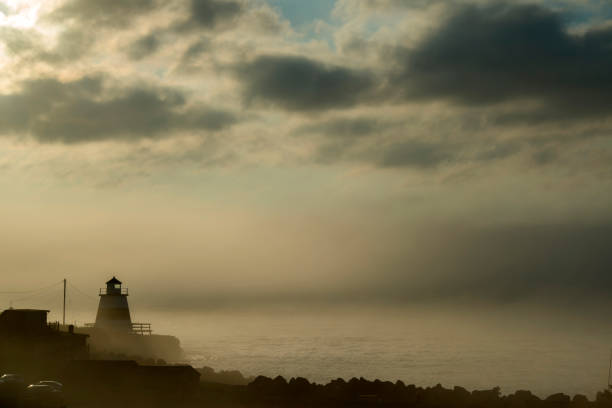 fog over a small wooden lighthouse by the Bay of Fundy