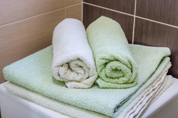 istock Rolled up fluffy spa towels on the shelf in modern bathroom interior. 1004533758