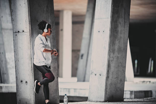 istock Young woman with  headphones checking her smartwatch 1004534730