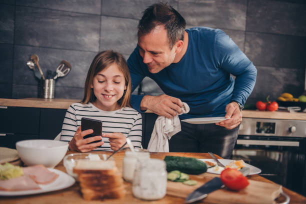 istock Daughter showing text message to a father 1004537072