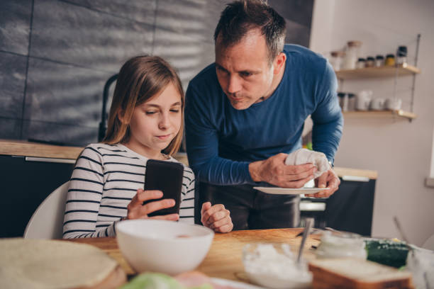 istock Daughter showing text message to a father 1004537216