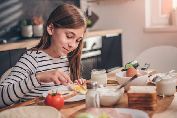 Girl having breakfast at home Girl having breakfast at home on sunny morning continental breakfast photos stock pictures, royalty-free photos & images