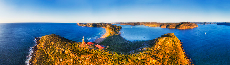 Barrenjoye head at the tip of Palm beach and Broken bay on Sydney northern beaches. Above elevated Lighthouse in wide aerial panorama.