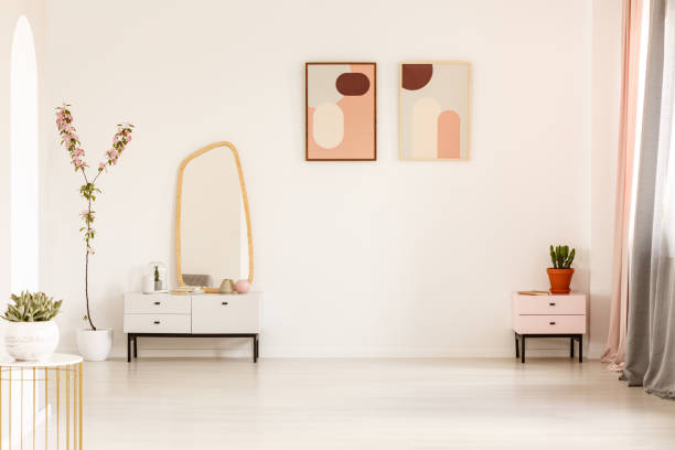 istock Mirror on white cabinet and plant in bright dressing room interior with posters and copy space. Real photo 1004564408
