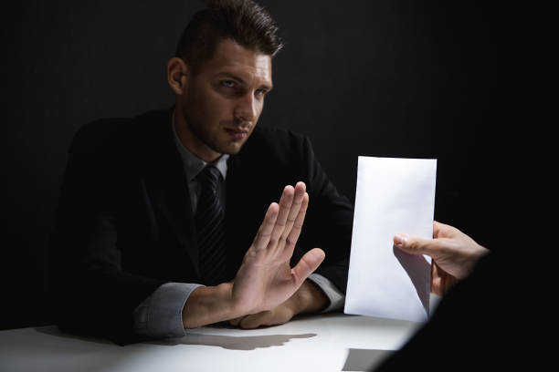 istock Businessman rejecting bribe money in white envelope offered by his partner 1004566630
