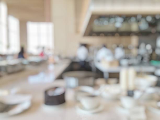 istock Open kitchen blur background in luxury hotel restaurant facility showing chef cooking over blurry food counter for buffet catering service 1004566730
