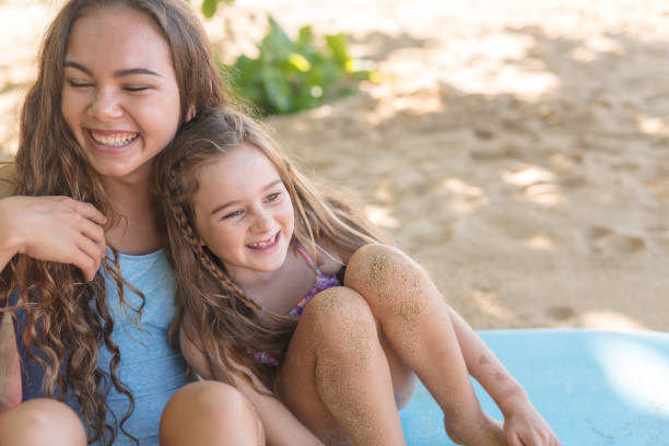 istock Two sisters relax with their boogie boards at the beach 1004603230