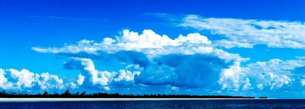 A Huge tropical atmospheric cloudy sky cloudscape with white coloured Cumulonimbus cloud formation in a blue sky. Beauty in nature. Fraser Island, Australia.