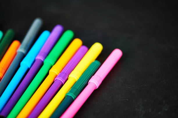 Colorful felt tip pens against weathered chalkboard