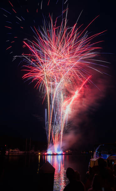 istock Colorful fireworks are launched from a barge over the water 1004654778
