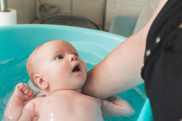 A 2-month old baby boy having a bath stock photo