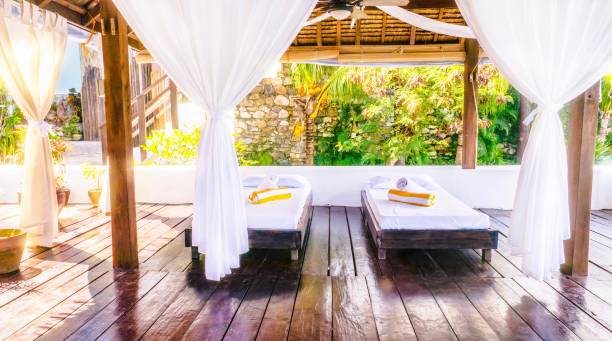 istock A light and airy, rustic, open-air massage room in the Philippines, with two simple beds on a wooden floor and pretty, boho style white curtains. 1004675788