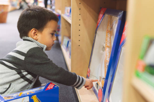 Little boy looking at toys in a toy store stock photo