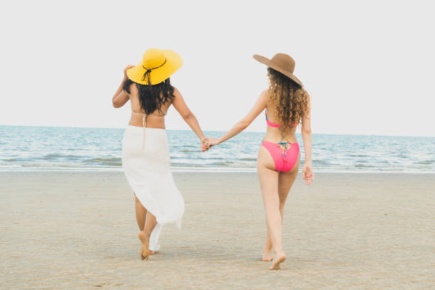 istock Happy women go sunbathing at sand beach in summer. 1004678994