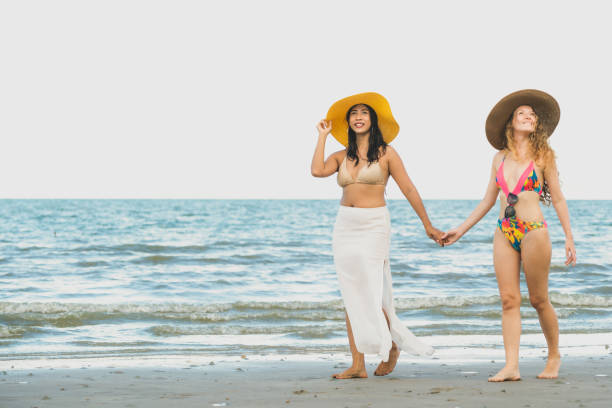 istock Happy women go sunbathing at sand beach in summer. 1004681040