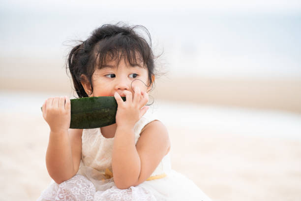 Adorable kid eating watermelon on the beach.