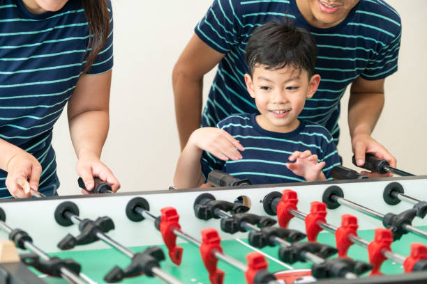 istock Happy kid playing foosball table with family. 1004681114