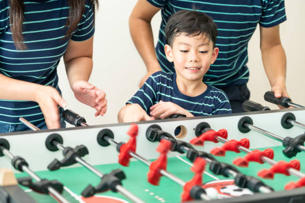 istock Happy kid playing foosball table with family. 1004681124