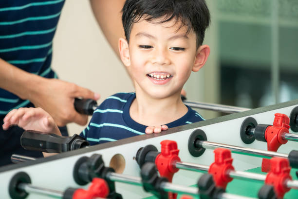 istock Happy kid playing foosball table with family. 1004681132