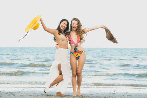 istock Happy women dance on sand beach in summer. 1004681136