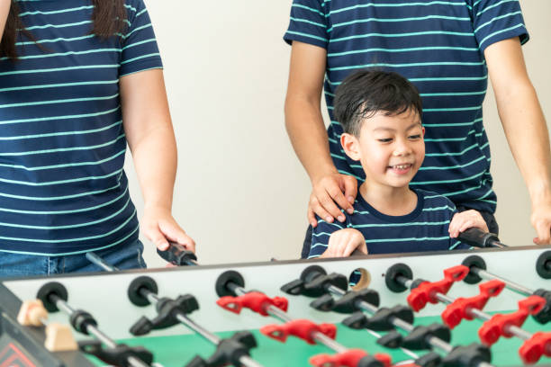 istock Happy kid playing foosball table with family. 1004681140