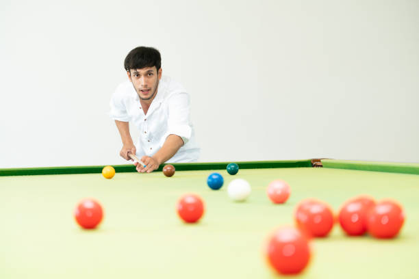 Young man playing snooker in the club.