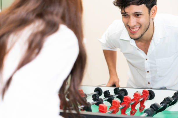 Happy couple playing foosball table.