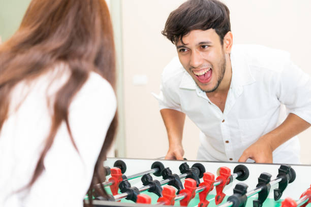 istock Happy couple playing foosball table. 1004681366
