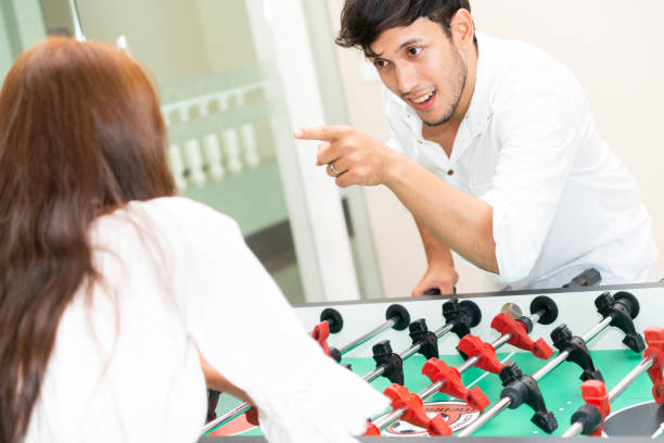 istock Happy couple playing foosball table. 1004681388
